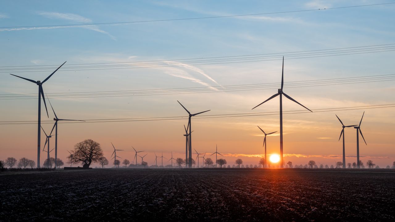 A serene sunset over wind turbines in Koningsbosch, Limburg, Netherlands.